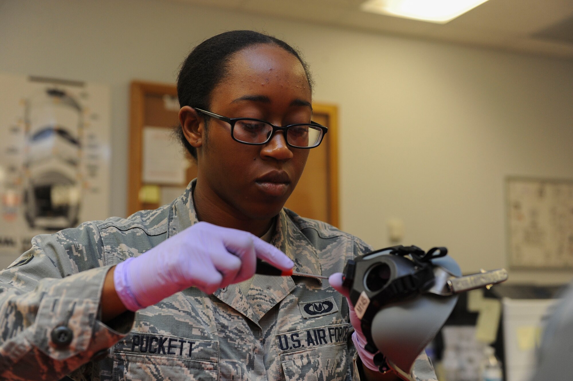 Airman 1st Class Shaquita Puckett, 5th Operations Support Squadron aircrew flight equipment technician, cleans a CRU-60/P connector at Minot Air Force Base, N.D., June 29, 2017. The CRU-60/P connects the aircraft oxygen supply-hose to aircrew members’ breathing masks. (U.S. Air Force Photo by Airman 1st Class Jessica Weissman)
