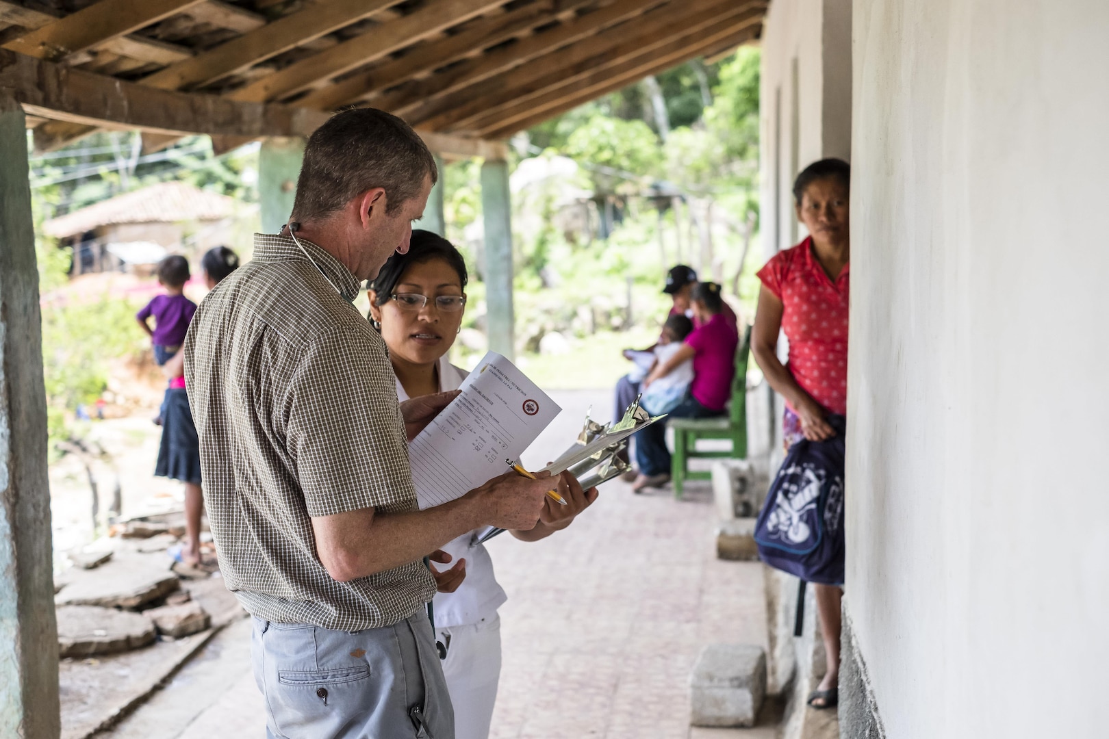 U.S. Army COL Douglas Lougee speaks with a Honduran nurse from the Ministry of Health about a  physical assessment on a child during a pediatric nutritional assessment mission. Joint Task Force – Bravo Medical Element personnel participated in a pediatric nutritional assessment mission as members of a joint team with the Honduran Ministry of Health to assess the nutritional status of children from the ages of 6 months to 60 months in the San Antonio area of La Paz, Honduras, Jun 14 - 15, 2017. 