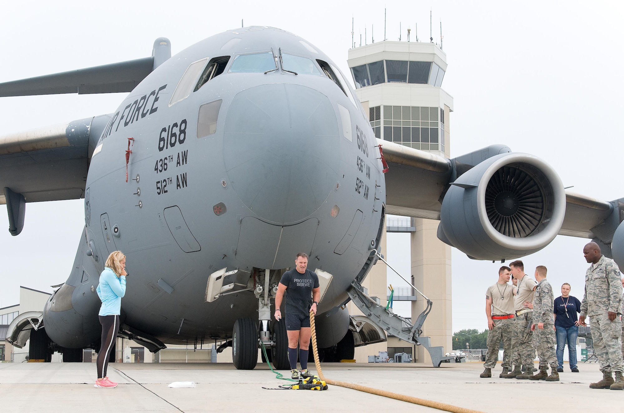 Cmdr. Grant Edwards, Australian Federal Police, Embassy of Australia, Washington, D.C., lines up his rope used for grip prior to his second attempt at pulling a C-17 Globemaster III, June 16, 2017, on Dover Air Force Base, Del. Kate Lord, Edwards’ wife, left, and members of the 712th and 736th Aircraft Maintenance Squadrons watched Edwards, an Australian strongman athlete, attempt to pull the C-17 weighing approximately 418,898 pounds. (U.S. Air Force photo by Roland Balik)