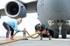 Kate Lord, wife of Cmdr. Grant Edwards, Australian Federal Police, Embassy of Australia, Washington, D.C., moves excess rope used for grip June 16, 2017, on Dover Air Force Base, Del. Edwards, an Australian strongman athlete, attempted pulling a C-17 Globemaster III after 736th Aircraft Maintenance Squadron maintainers repositioned the aircraft for his third attempt at pulling the aircraft weighing 418,898 pounds. He is scheduled to attempt pulling a C-17 during the “Thunder Over Dover: 2017 Dover AFB Open House,” Aug. 26-27. (U.S. Air Force photo by Roland Balik)