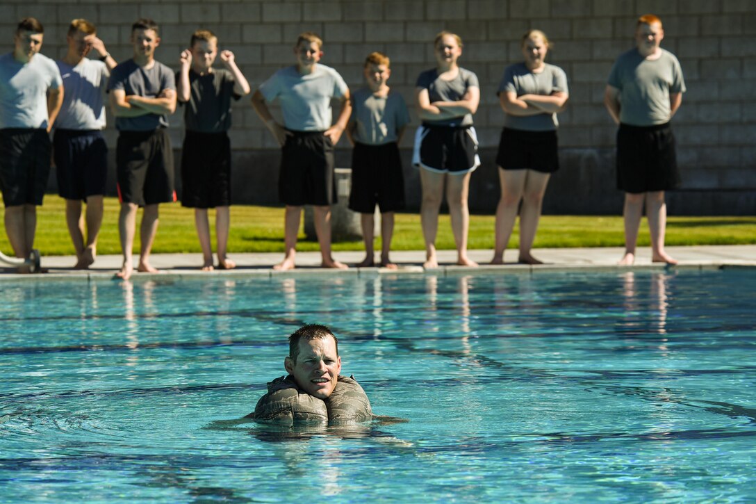 Staff Sgt. Tim Everhard demonstrates using his Airman Battle Uniform (ABU) for flotation during the Desert Hawk XV encampment, West Wendover municipal pool, West Wendover, Nevada, June 22, 2017. (U.S. Air Force photo/R. Nial Bradshaw)