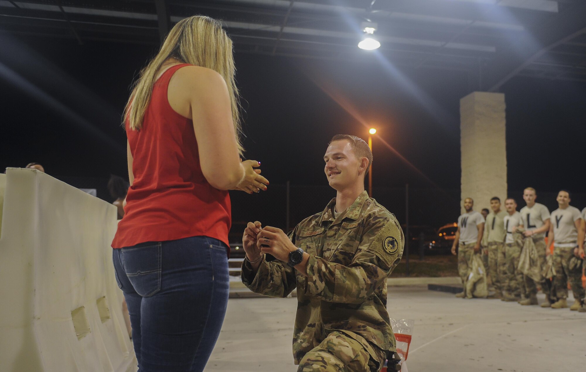 Staff Sgt. Shane Schubot, a tactical aircraft maintainer with the 1st Special Operations Maintenance Squadron, proposes to his girlfriend during Operation Homecoming at Hurlburt Field, Fla., July 5, 2017. A row of 15 Air Commandos stood behind Schubot with letters on their shirts spelling out, “Will you marry me?” as he got down on one knee to pop the question. (U.S. Air Force photo by Airman 1st Class Isaac O. Guest IV)