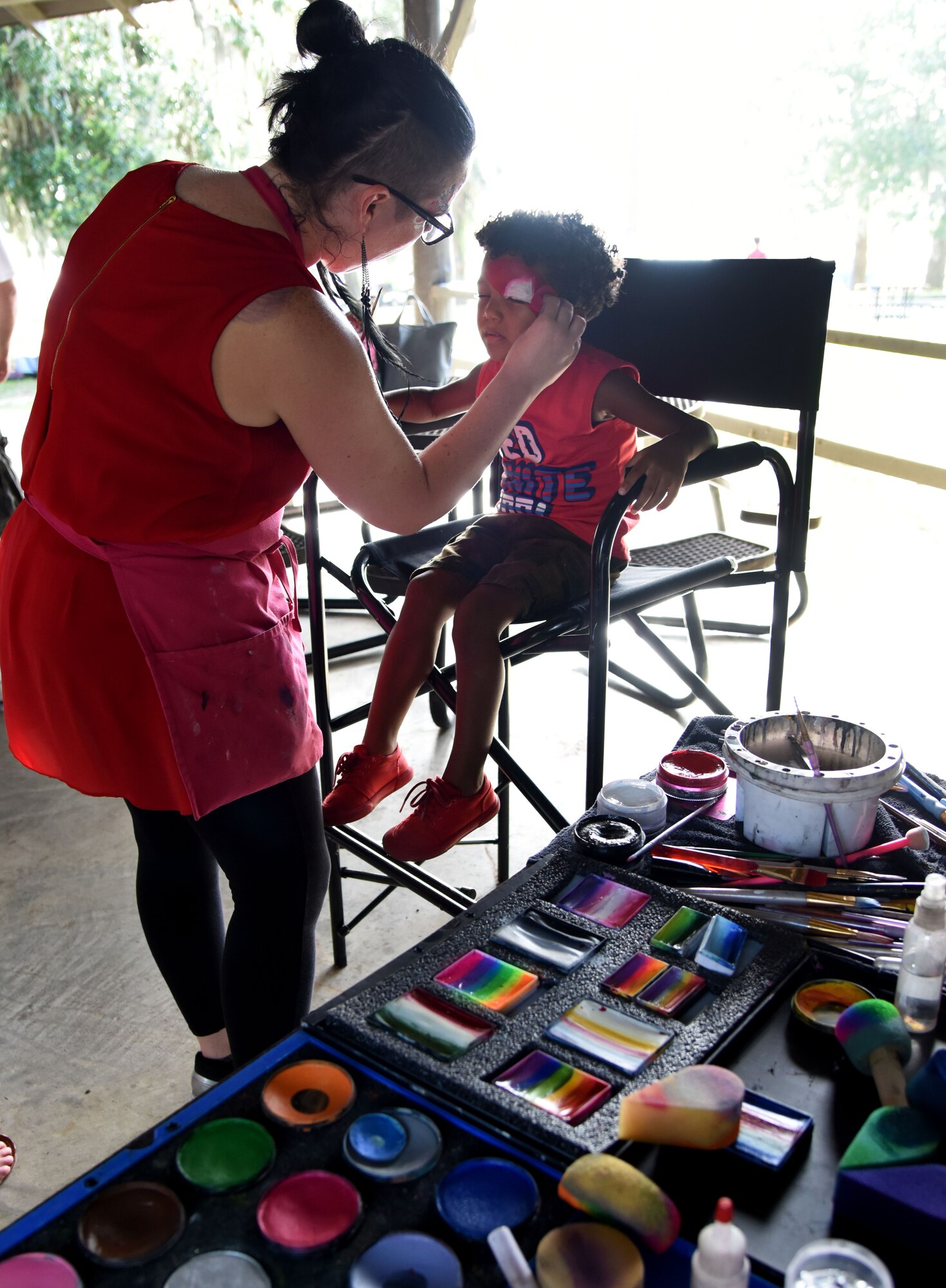 Lindsey Hand, Swirls Face Painting owner, paints the face of Courtney Hill II, son of Tech. Sgt. Courtney Hill, 81st Security Forces Squadron pass and ID NCO in charge, during the Pops in the Park event at Marina Park July 1, 2017, on Keesler Air Force Base, Miss. The event also included a kids’ fishing rodeo, mullet toss, fireworks display and music performances. (U.S. Air Force photo by Kemberly Groue)