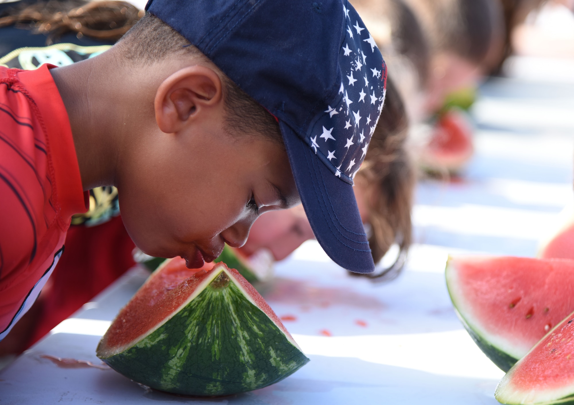 Josiah Trombley, son of Chief Master Sgt. Leonard Trombley, 81st Training Support Squadron superintendent, participates in the watermelon eating competition during the Pops in the Park event at Marina Park July 1, 2017, on Keesler Air Force Base, Miss. The event also included a kids’ fishing rodeo, mullet toss, fireworks display and music performances. (U.S. Air Force photo by Kemberly Groue)