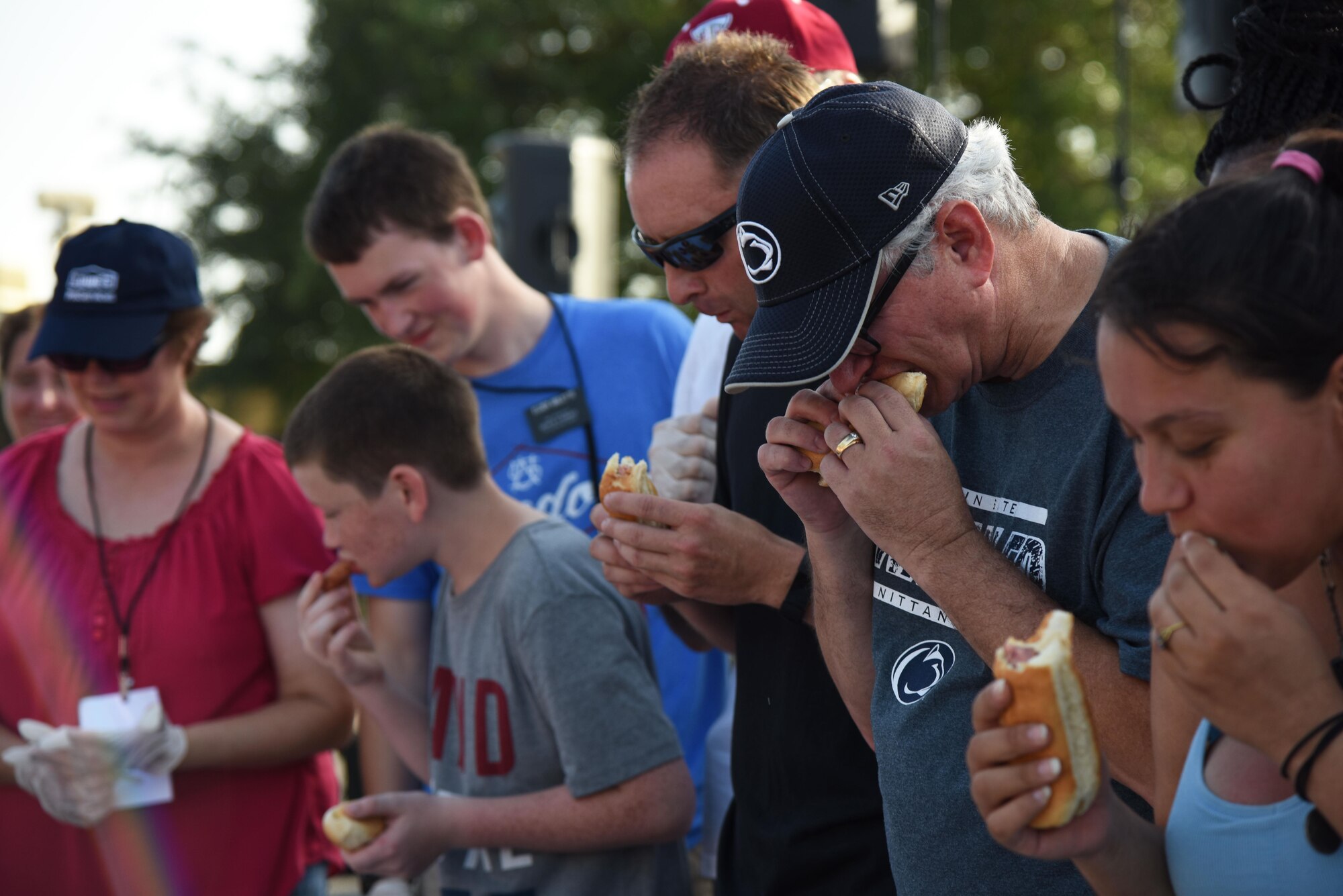 Keesler personnel participate in the hot dog eating competition during the Pops in the Park event at Marina Park July 1, 2017, on Keesler Air Force Base, Miss. The event also included a kids’ fishing rodeo, mullet toss, fireworks display and music performances. (U.S. Air Force photo by Kemberly Groue)
