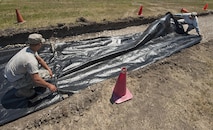 From left, Airman 1st Class Christopher Schroeder and Senior Airman Thomas Clark, 5th Civil Engineer Squadron pavements and equipment technicians, cover geotextile over the ground at Minot Air Force Base, N.D., June 12, 2017. Geotextiles are permeable fabrics used in conjunction with soil to separate, filter, reinforce, protect and drain water. (U.S. Air Force photo by Airman 1st Class Jonathan McElderry)