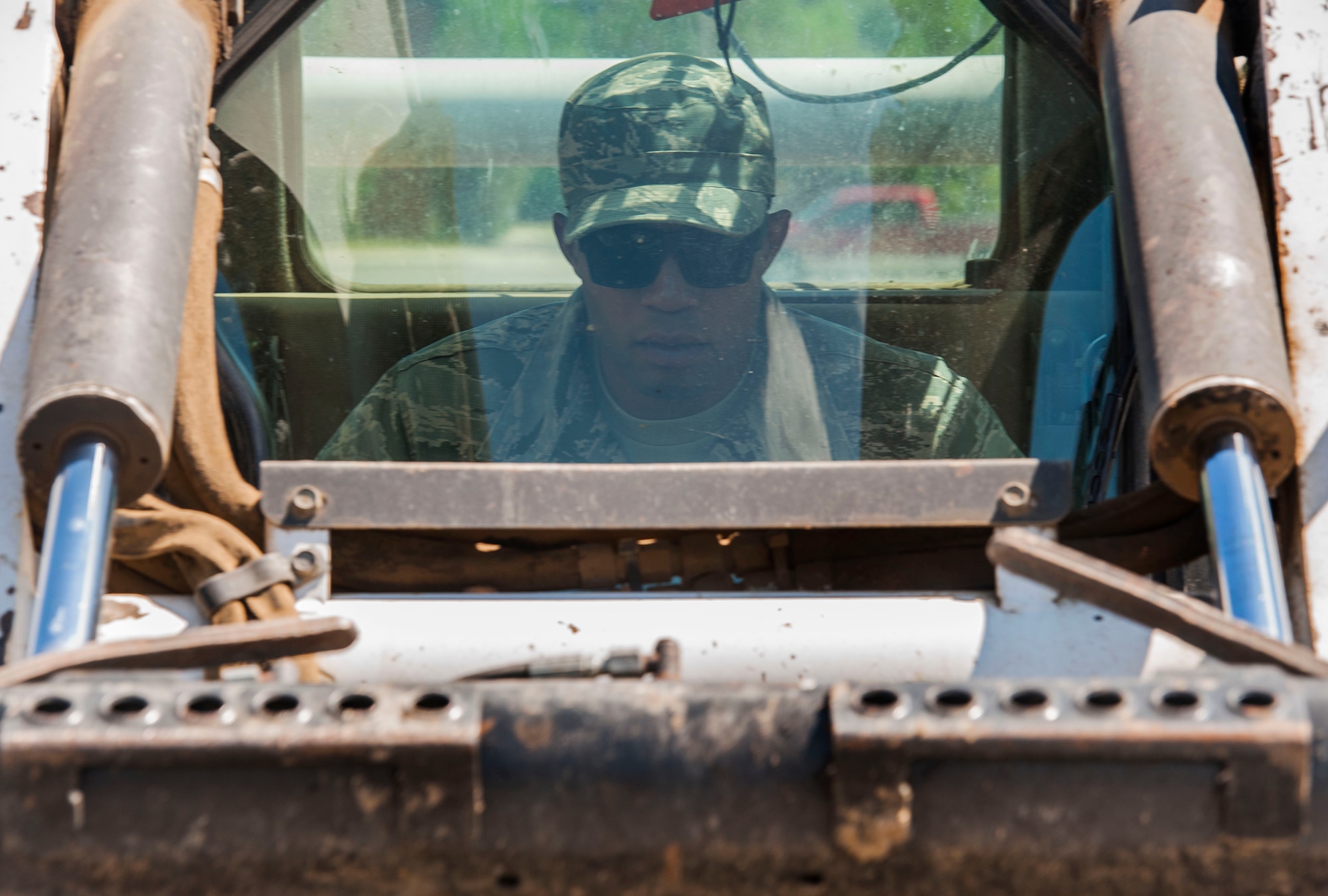 Airman 1st Class Harold McIntyre, 5th Civil Engineer Squadron pavements and equipment technician, operates a loader at Minot Air Force Base, N.D., June 12, 2017. After assessing which sections of sidewalk needed to be removed, the CES Airmen made relief cuts to the cracked concrete before replacing it. (U.S. Air Force photo by Airman 1st Class Jonathan McElderry)