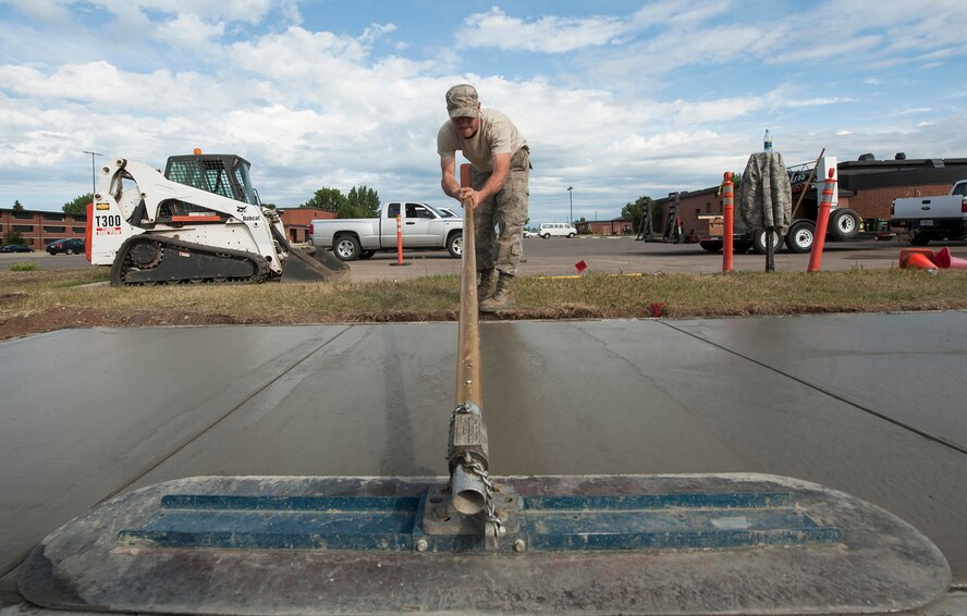 Staff Sgt. Ryan Powell, 5th Civil Engineer Squadron heavy equipment operator, pushes a fresno trowel at Minot Air Force Base, N.D., June 29, 2017. The fresno trowel is one of several tools used to smooth concrete surfaces for their finish coats before being left to dry. (U.S. Air Force photo by Airman 1st Class Jonathan McElderry)