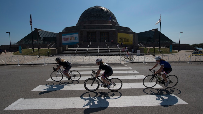 Athletes ride past Adler Planetarium during the cycling competition for the 2017 Department of Defense Warrior Games in Chicago, Ill., July 6, 2017. The annual games allow wounded, ill and injured service members and veterans to compete in paralympic-style sports including archery, cycling, field, shooting, sitting volleyball, swimming, track and wheelchair basketball. DoD photo by Roger L. Wollenberg