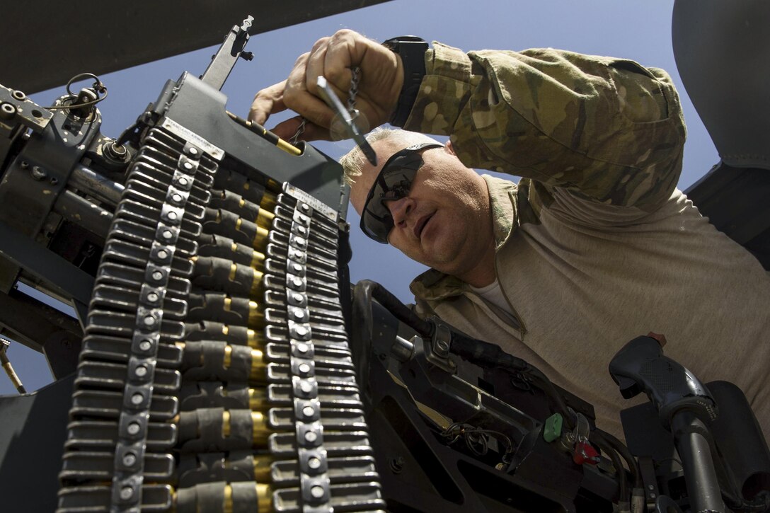 Air Force Tech. Sgt. Wayne Cowen loads ammunition into a .50-caliber machine gun at Bagram Airfield, Afghanistan, July 4, 2017. Cowen is a special missions aviator assigned to the 83rd Expeditionary Rescue Squadron. Air Force photo by Staff Sgt. Benjamin Gonsier