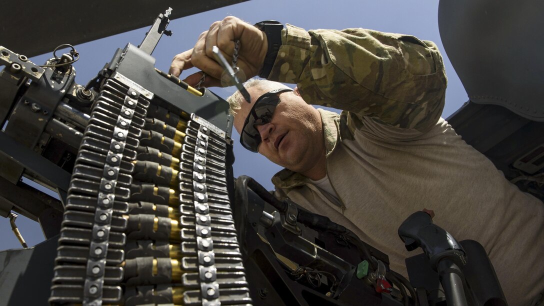 Air Force Tech. Sgt. Wayne Cowen loads ammunition into a .50-caliber machine gun at Bagram Airfield, Afghanistan, July 4, 2017. Cowen is a special missions aviator assigned to the 83rd Expeditionary Rescue Squadron. Air Force photo by Staff Sgt. Benjamin Gonsier