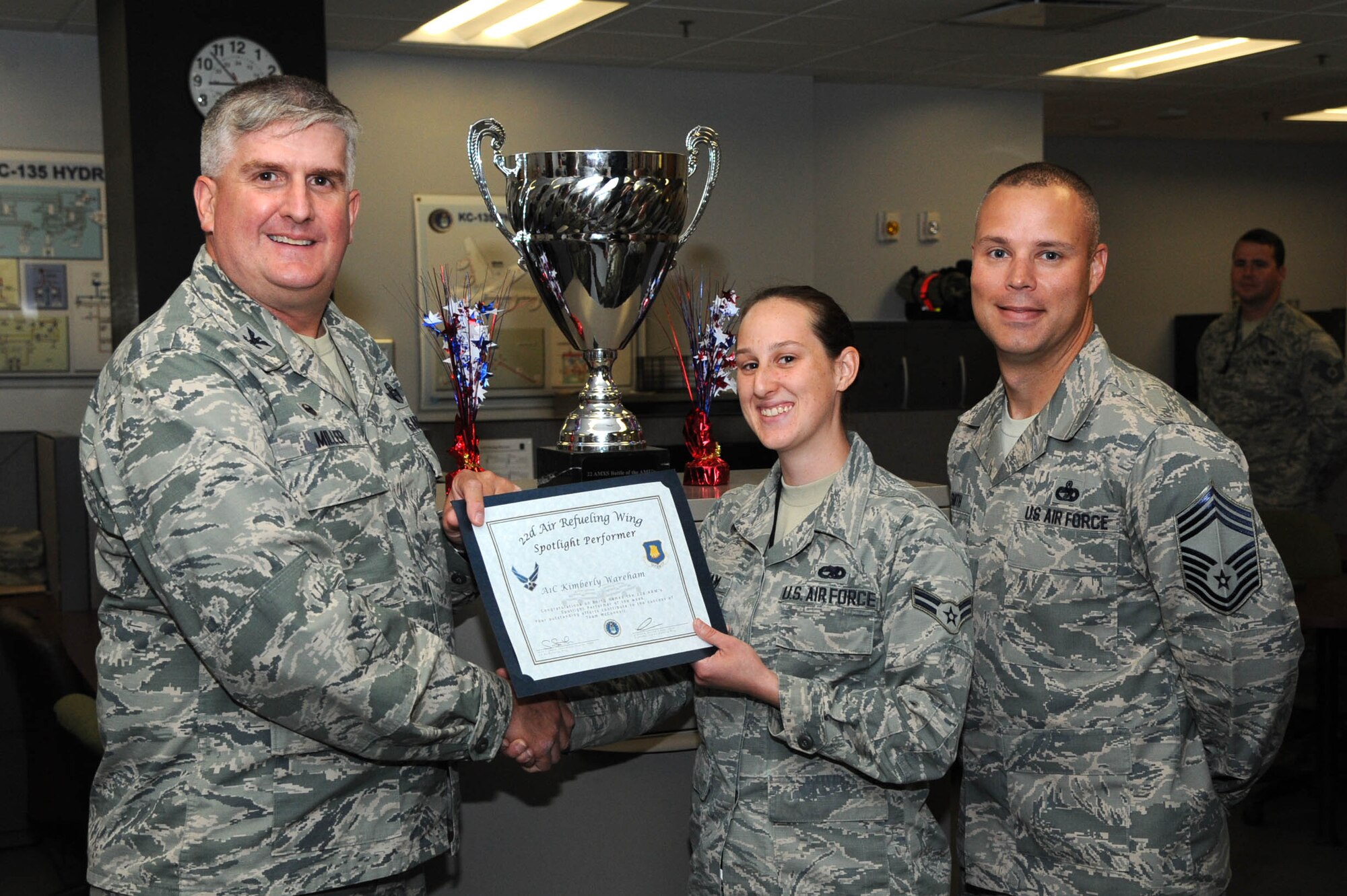 Airman 1st Class Kimberly Wareham, 22nd Aircraft Maintenance Squadron aerospace propulsion journeyman, poses with Col. Albert Miller, 22nd Air Refueling Wing commander, and Chief Master Sgt. Sean Smith, 22nd Mission Support Group superintendent, June 29, 2017, at McConnell Air Force Base, Kan. Wareham received the spotlight performer for the week of May 22-26. (U.S. Air Force photo/Senior Airman Jenna K. Caldwell) 
