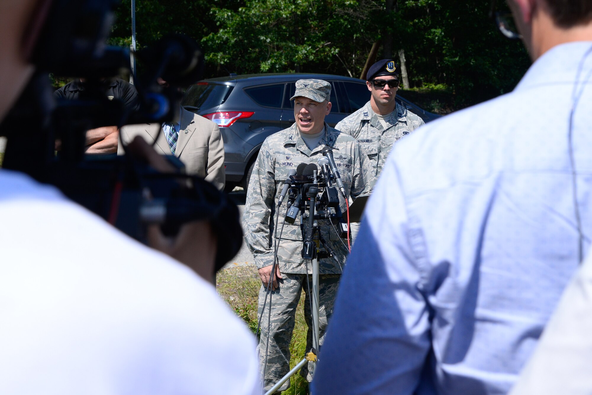 Col. Roman L. Hund, installation commander, speaks to members of the media outside the Vandenberg Gate at Hanscom Air Force Base, Mass., shortly after the base returned to normal operations July 6. Earlier in the day, members of the 66th Security Forces Squadron detected some potentially explosive material during a routine vehicle inspection, which caused officials to close the Vandenberg Gate and evacuate several nearby base facilities. Explosive materials experts from the Mass. State Police eventually cleared the truck and the scene while taking samples from interior containers for additional evaluation. (U.S. Air Force photo by Mark Herlihy)