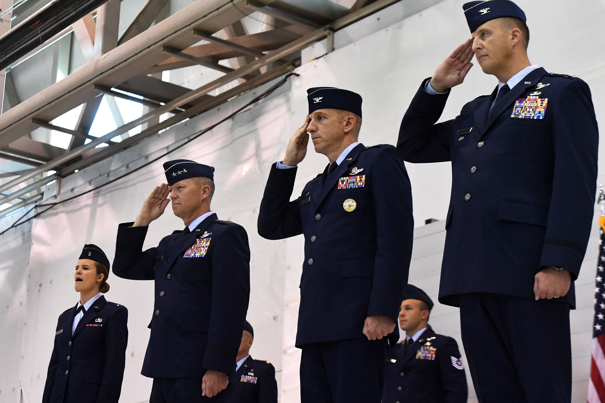 Lt. Gen. Mark Kelly, 12th Air Force commander, Col. Case Cunningham, outgoing 432nd Wing commander and Col. Julian Cheater, incoming 432nd Wing commander, salute during the singing of the national anthem at the 432nd Wing change of command July 6, 2017, at Creech Air Force Base, Nev. During the event, Col. Cheater assumed command from Col. Cunningham in front of a crowd of Airmen, peers and family members. (U.S. Air Force photo/Airman 1st Class James Thompson)