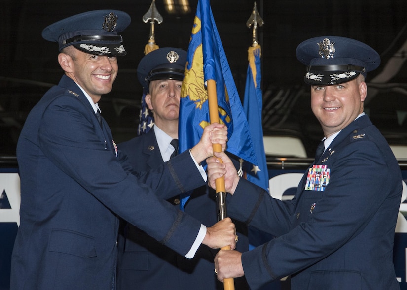 Col. E. John Teichert, left, 11th Wing and Joint Base Andrews commander, hands the 11th MSG guidon to Col. Bradley L. Johnson, 11th MSG commander, during a change of command ceremony at Joint Base Andrews, Md., July 6, 2017. Johnson replaced Col. William H. Kale III as 11th MSG commander. Johnson will preside over 1,500 personnel providing civil engineer, contracting, force support and logistics capabilities to 16,000 personnel throughout the National Capital Region. (U.S. Air Force photo by Senior Airman Jordyn Fetter)