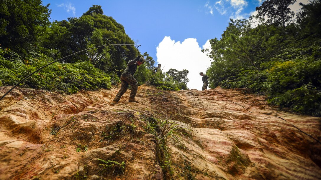 Marines rappel down a mud wall during a jungle warfare course at Camp Gonsalves in Okinawa, Japan, July 5, 2017. The Marines are assigned to Bravo Company, 1st Battalion, 3rd Marine Regiment. Marine Corps photo by Cpl. Aaron S. Patterson
