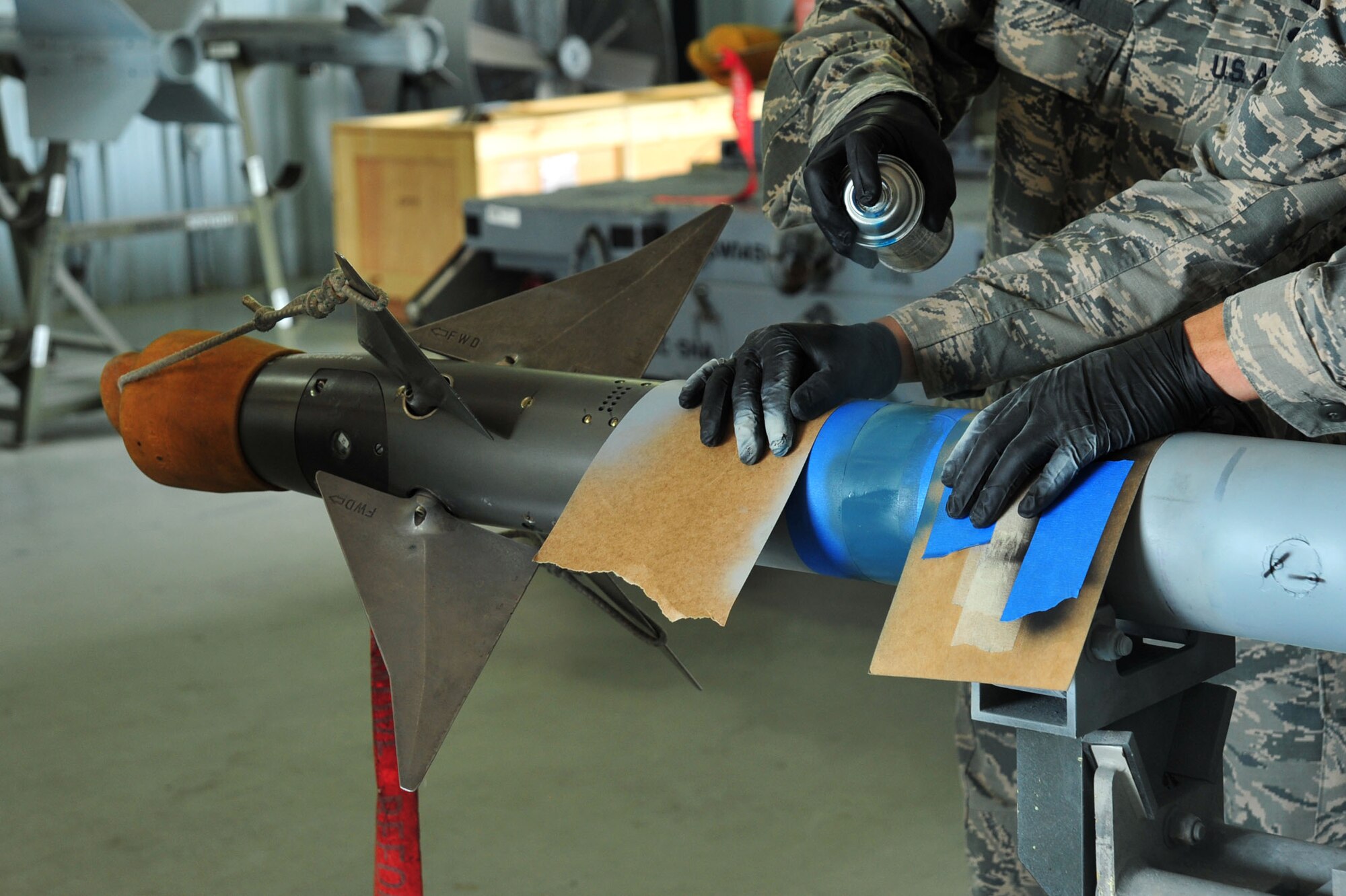 U.S. Airmen assigned to the 20th Equipment Maintenance Squadron work together to apply primer to an AIM-9 Sidewinder missile at Shaw Air Force Base; S.C.; June 27; 2017. The Airmen used the primer to cover metal exposed due to scratches or removal of rust. (U.S. Air Force photo by Airman 1st Class Kathryn R.C. Reaves)