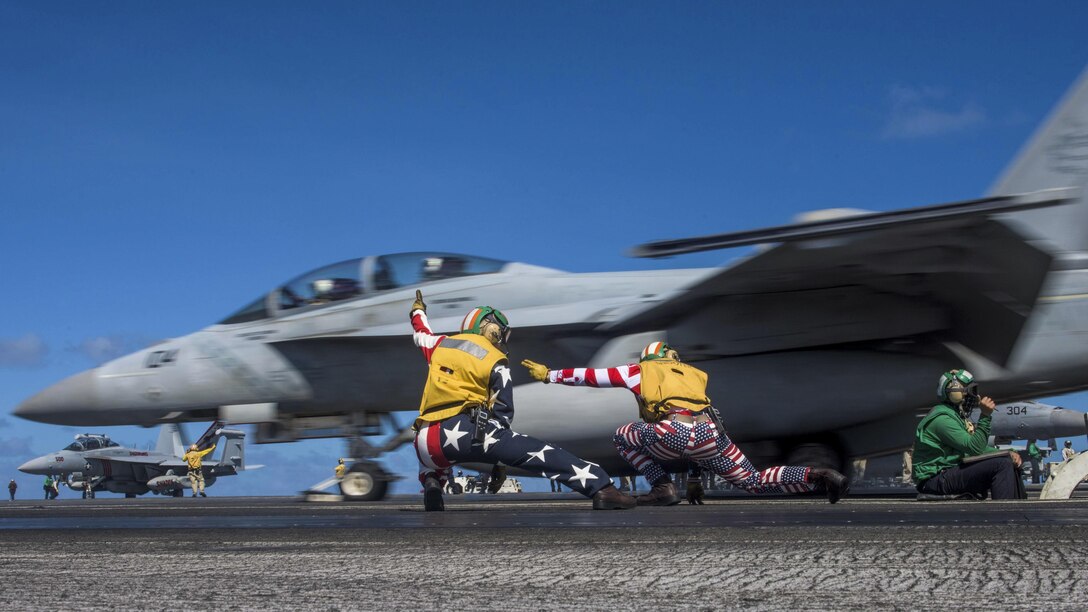 Navy Lts. Miranda Krasselt and Chris Williams signal for the launch of an F/A-18F Super Hornet on the flight deck of the aircraft carrier USS Ronald Reagan in the Pacific Ocean, July 4, 2017. The Ronald Reagan is on patrol in the U.S. 7th Fleet area of responsibility to support security and stability in the Indo-Asia-Pacific region. Navy photo by Petty Officer 2nd Class Kenneth Abbate