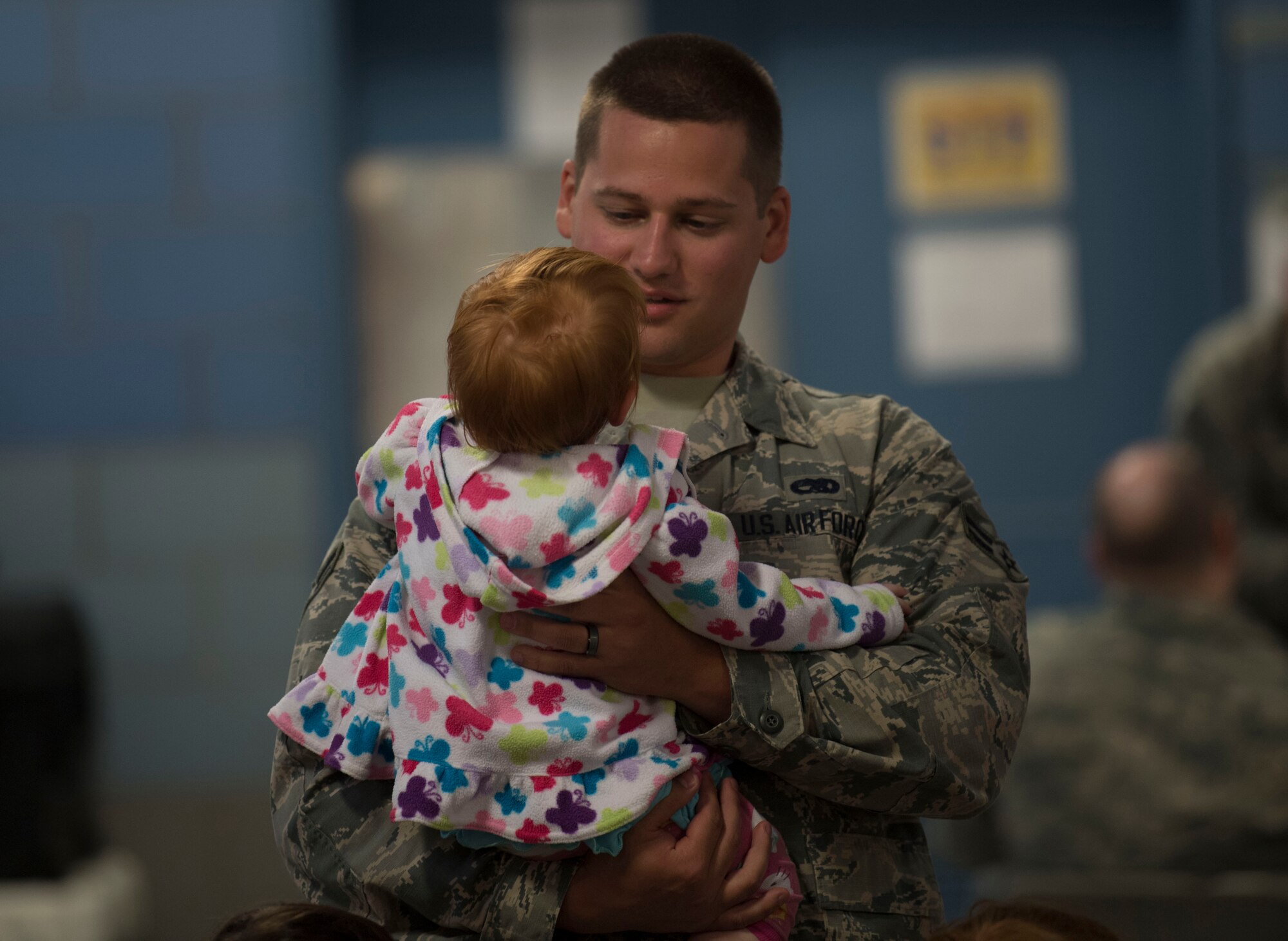 Airman 1st Class Cody Lusk holds Elaina Mullens, the child of Senior Airman Justin Mullins, prior to departing McLaughlin Air National Guard base for a deployment in support of Operation Freedom’s Sentinel on June 25, 2017. Lusk and Mullens are aircraft structural maintainers assigned to the 130th Aircraft Maintenance Squadron. (U.S. Air National Guard photo by Tech. Sgt. De-Juan Haley)