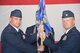 Col. Richard L. Land III, 552nd Operations Group commander, left, passes the unit guidon to Lt. Col. James Ord, the new 960th Airborne Air Control Squadron commander, June 28. Awaiting the guidon is Master Sgt. Tommy Stidham, 960th AACS first sergeant. (Air Force photo by Ron Mullan)