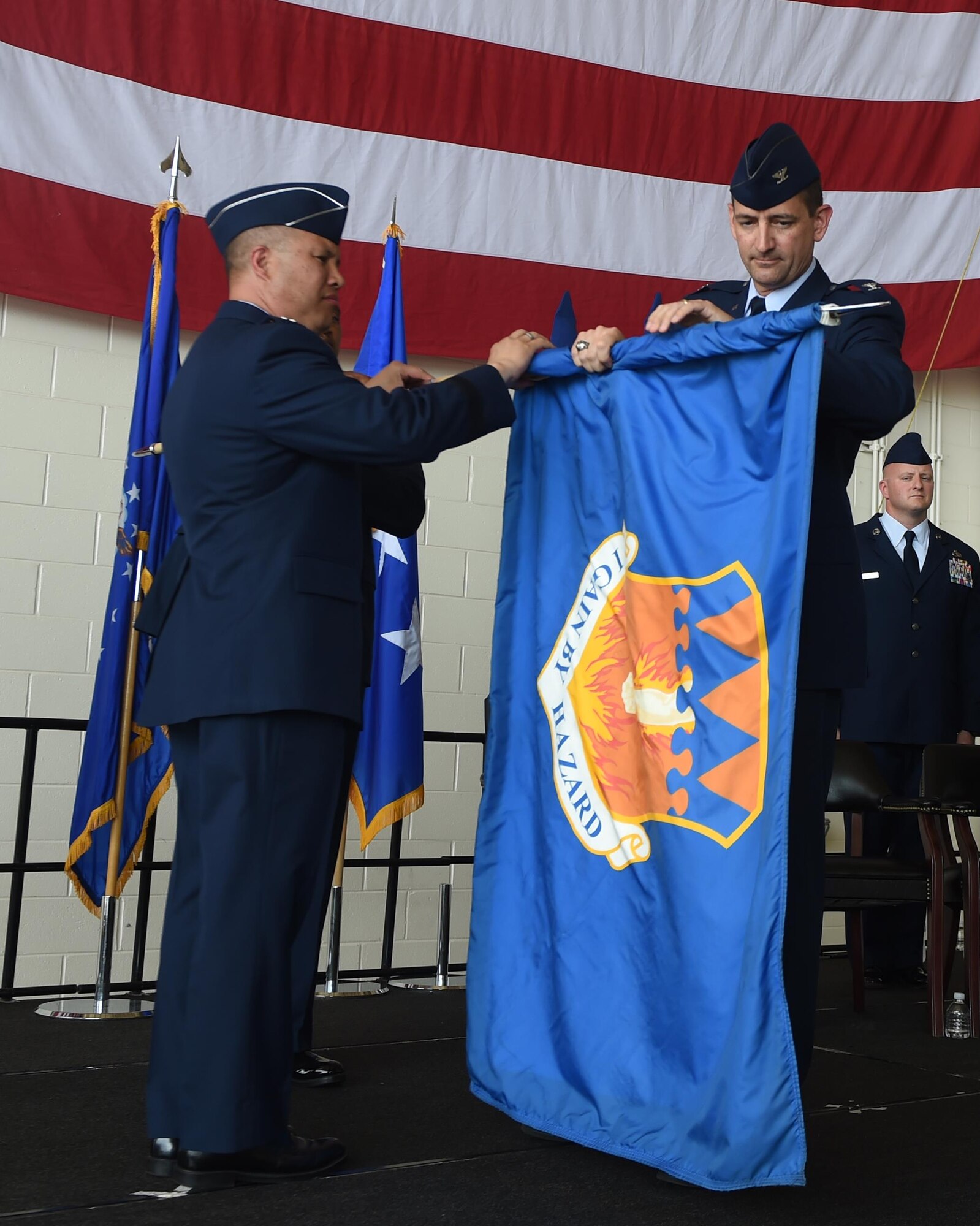 U.S. Air Force Lt. Gen. Giovanni Tuck, 18th Air Force Commander, and Col. Stephen Hodge, 317th Airlift Group commander, furl the 317th AG unit flag at Dyess Air Force Base, Texas July 6, 2017. The 317th Airlift Group was deactivated and subsequently activated as the 317th Airlift Wing. (U.S. Air Force photo by Senior Airman Alexander Guerrero)
