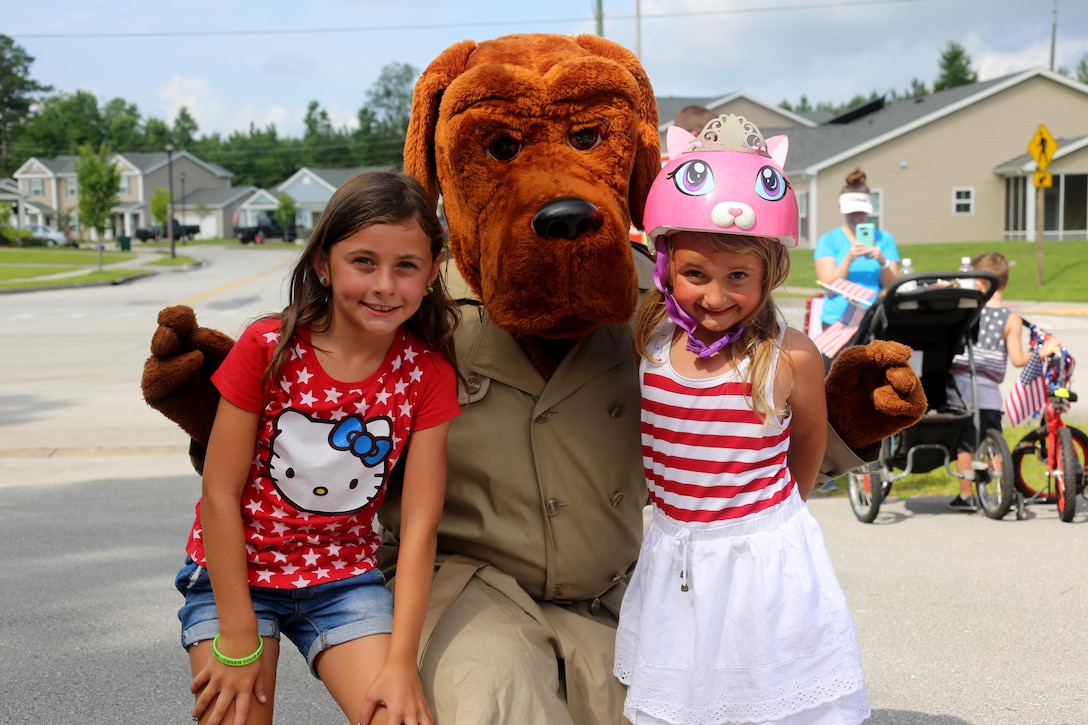 Ashlyn, 8, left, and Adelyn, 5, pose with McGruff the Crime Dog during the first Independence Day Youth Parade at Marine Corps Air Station Cherry Point, N.C., July 4, 2017. Nearly 100 members of the Cherry Point community joined in on the red, white and blue parade. The mile-long bike parade was organized by housing resident Caitlin Chemelewski as a patriotic and fun event for the kids, and to bring the MCAS Cherry Point community together on Independence Day. (U.S. Marine Corps photo by Cpl. Jason Jimenez/ Released)