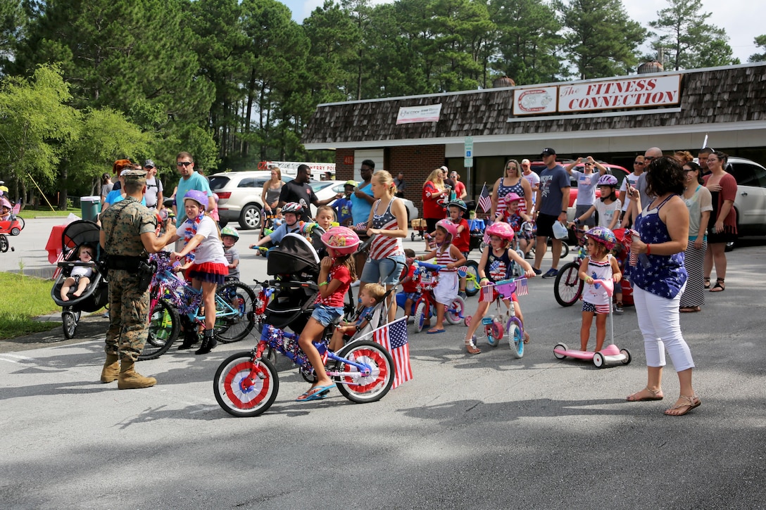 Families ready themselves to start a bike parade during the first Independence Day Youth Parade at Marine Corps Air Station Cherry Point, N.C., July 4, 2017. The MCAS Cherry Point Provost Marshal’s Office ensured the Independence Day fun was enjoyed safely with their vehicles leading participants through the mile-long route.  Cherry Point’s very own McGruff the Crime Dog and Sparky the Fire Dog interacted with children. Nearly 100 members of the Cherry Point community participated in the red, white and blue parade. (U.S. Marine Corps photo by Cpl. Jason Jimenez/ Released)