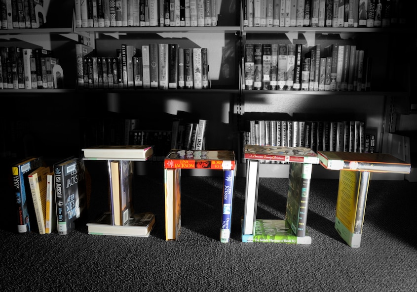 Books from the base library are stacked at Minot Air Force Base, N.D., July 6, 2017. The library was recently awarded Air Force Library Program of the Year for 2016. This award is given to the library that excels in mission accomplishment and innovation, leadership and management, and customer focus. (U.S. Air Force illustration by Senior Airman Sahara L. Fales)