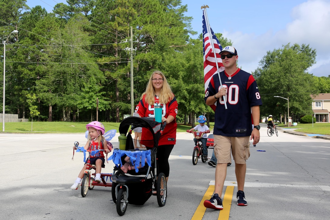 Community members parade through their neighborhood during the first Independence Day Youth Parade at Marine Corps Air Station Cherry Point, N.C., July 4, 2017. Escorted by Cherry Point police, the event catered to younger family members, but encouraged the larger community to come together. Nearly 100 Cherry Point community residents gathered for the festivities. (U.S. Marine Corps photo by Cpl. Jason Jimenez/ Released)