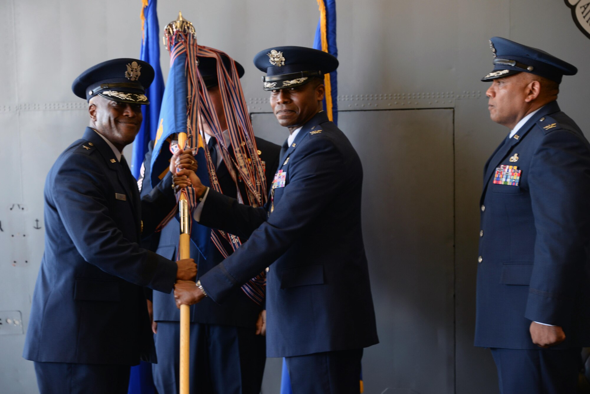Col. Jason Childs hands off the guidon to Brig. Gen. Ronald E. Jolly Sr. during the 982nd Change of Command ceremony July 7, 2017. Col. Childs passed on command of the 982nd TRG to Col. Anthony Puente. (U.S. Air Force photo by Senior Airman Robert L. McIlrath)