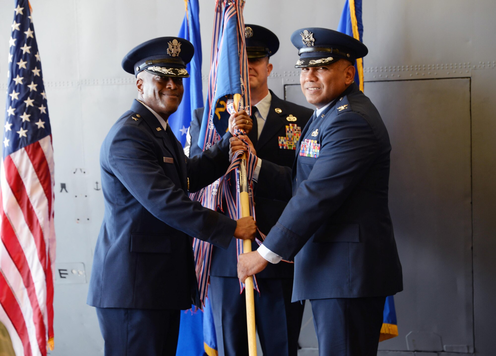 Brig. Gen. Ronald E. Jolly Sr., 82nd Training Wing commander, passes the ceremonial guidon to Col. Anthony Puente, incoming 982nd Training Group commander, during the 982nd TRG Change of Command ceremony at Sheppard Air Force Base, Texas, July 7, 2017.