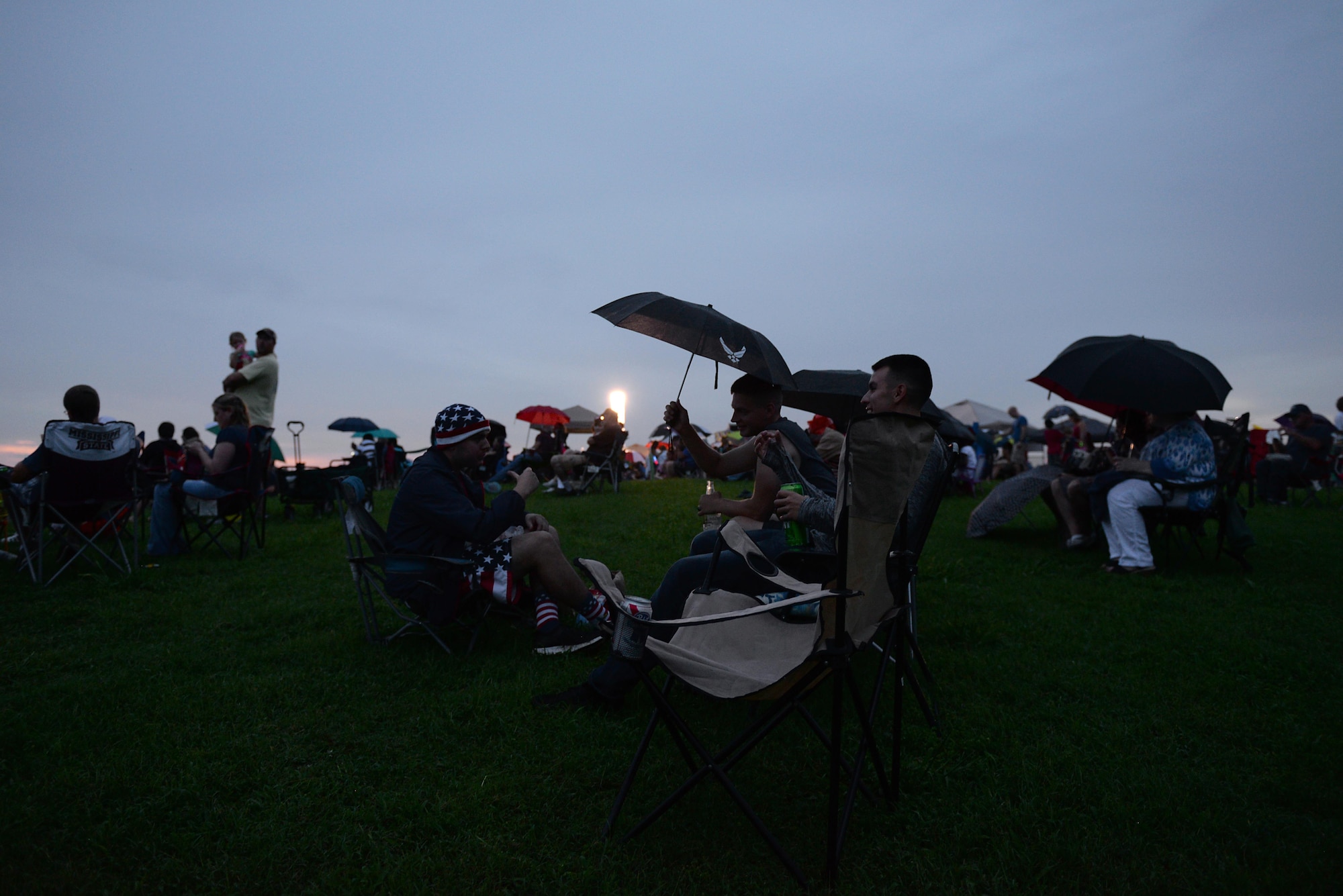 Family and friends gather as the sun sets during Fireworks on the Water July 1, 2017, at the Stennis Lock and Dam in Columbus, Mississippi. People stayed entertained by the bouncy obstacle courses, tossing footballs, talking with friends or vendors and dancing to music being played from the stage’s pre-made playlist.