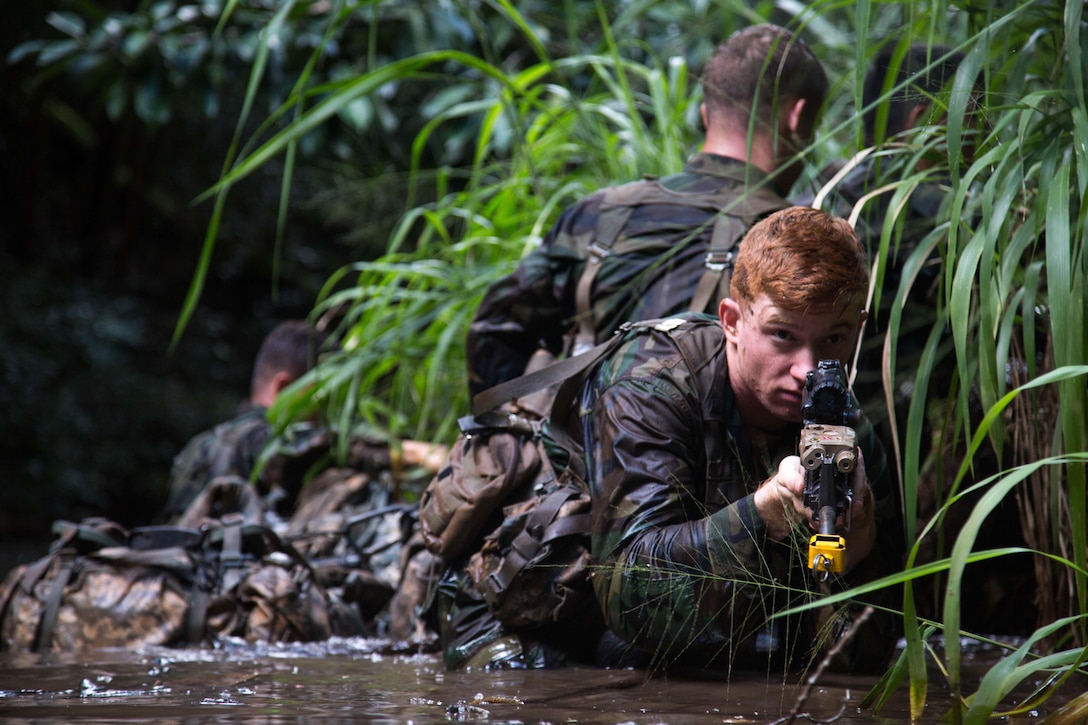 A U.S. Army Soldier, assigned to the 25th Infantry Division, sets security while his team secures a riverbank during the Waterborne Operations portion of the Jungle Operations School at the 25th Infantry Division East Range Training Complex, Hawaii, 21 Jan., 2015. The students learn and become proficient at operating and surviving in the jungle environment. (U.S. Army photo by Spc. James K. McCann / Released)