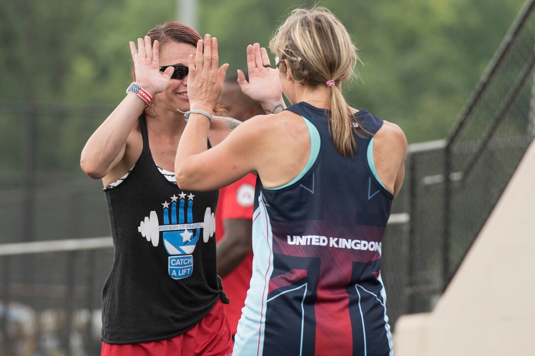 Marine Corps veteran Sarah Rudder, left, high fives Royal Air Force veteran Flight Lieutenant Jannine Church during practice for track competition during the 2017 Department of Defense (DoD) Warrior Games in Chicago, Ill., June 30, 2017. Rudder was helping Church with her race starts. The DoD Warrior Games are an annual event allowing wounded, ill and injured service members and veterans to compete in Paralympic-style sports including archery, cycling, field, shooting, sitting volleyball, swimming, track and wheelchair basketball.    (DoD photo by Roger L. Wollenberg)