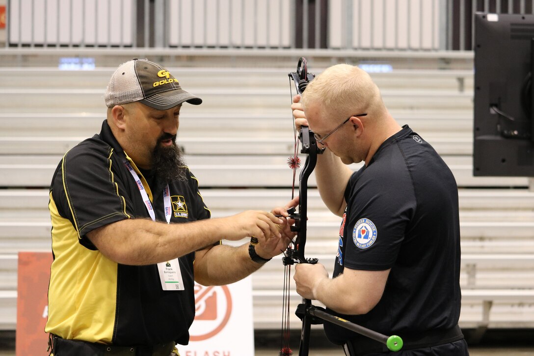 Team Army archery coach Frank Barroquiero assists U.S. Army National Guard Spc. Jay Marquiss with the sight of this compound bow before a  training session, June 29, at McCormick Place Convention Center, Chicago, Illinois, for the 2017 Department of Defense Warrior Games. The DOD Warrior Games are an adaptive sports competition for wounded, ill and injured service members and veterans. Approximately 265 athletes representing teams from the Army, Marine Corps, Navy, Air Force, Special Operations Command, United Kingdom Armed Forces, and the Australian Defence Force will compete June 30 – July 8 in archery, cycling, track, field, shooting, sitting volleyball, swimming, and wheelchair basketball. (U.S. Army photo by Robert A. Whetstone)