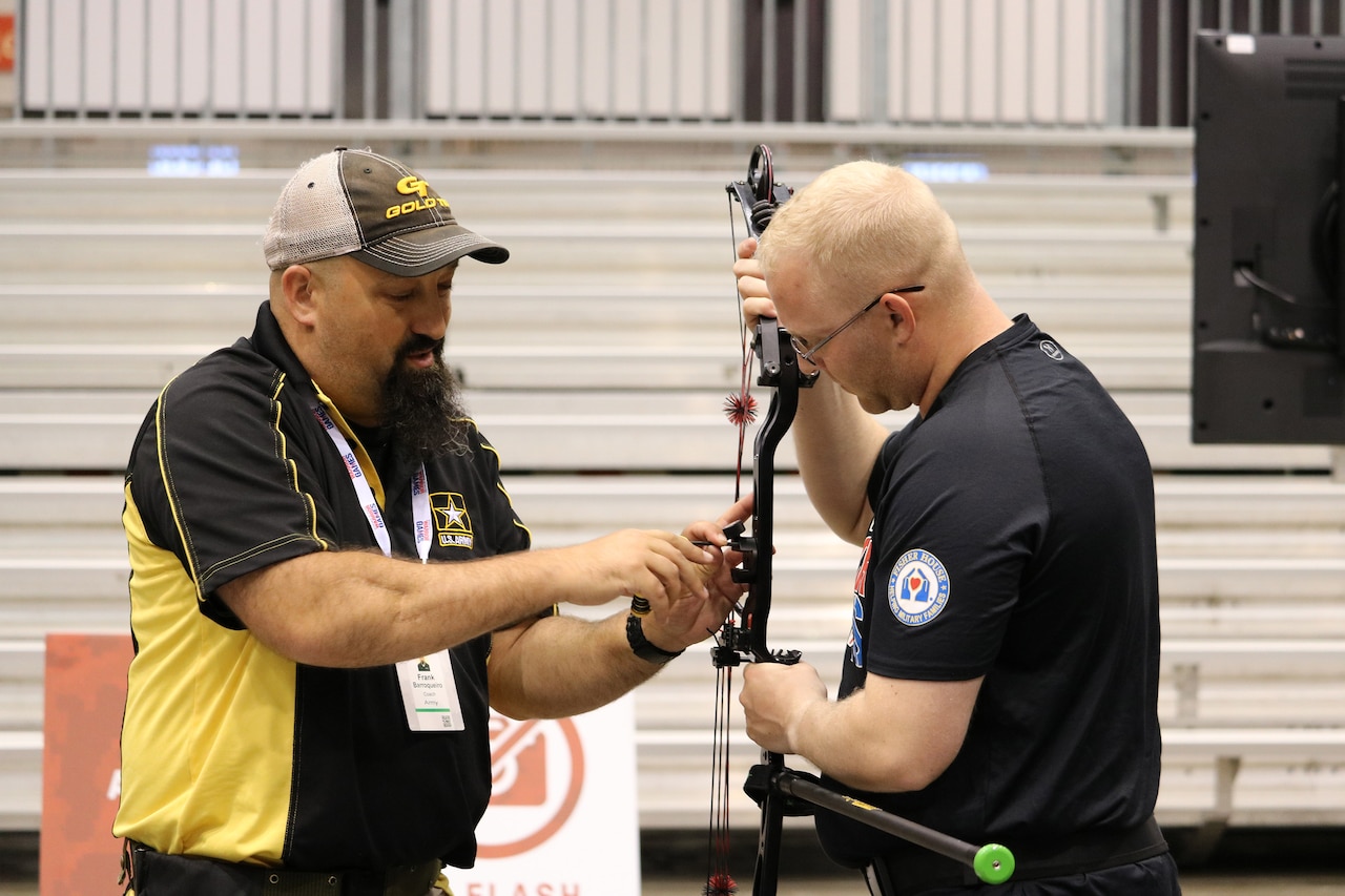 Team Army archery coach Frank Barroquiero assists U.S. Army National Guard Spc. Jay Marquiss with the sight of this compound bow before a  training session, June 29, at McCormick Place Convention Center, Chicago, Illinois, for the 2017 Department of Defense Warrior Games. The DOD Warrior Games are an adaptive sports competition for wounded, ill and injured service members and veterans. Approximately 265 athletes representing teams from the Army, Marine Corps, Navy, Air Force, Special Operations Command, United Kingdom Armed Forces, and the Australian Defence Force will compete June 30 – July 8 in archery, cycling, track, field, shooting, sitting volleyball, swimming, and wheelchair basketball. (U.S. Army photo by Robert A. Whetstone)