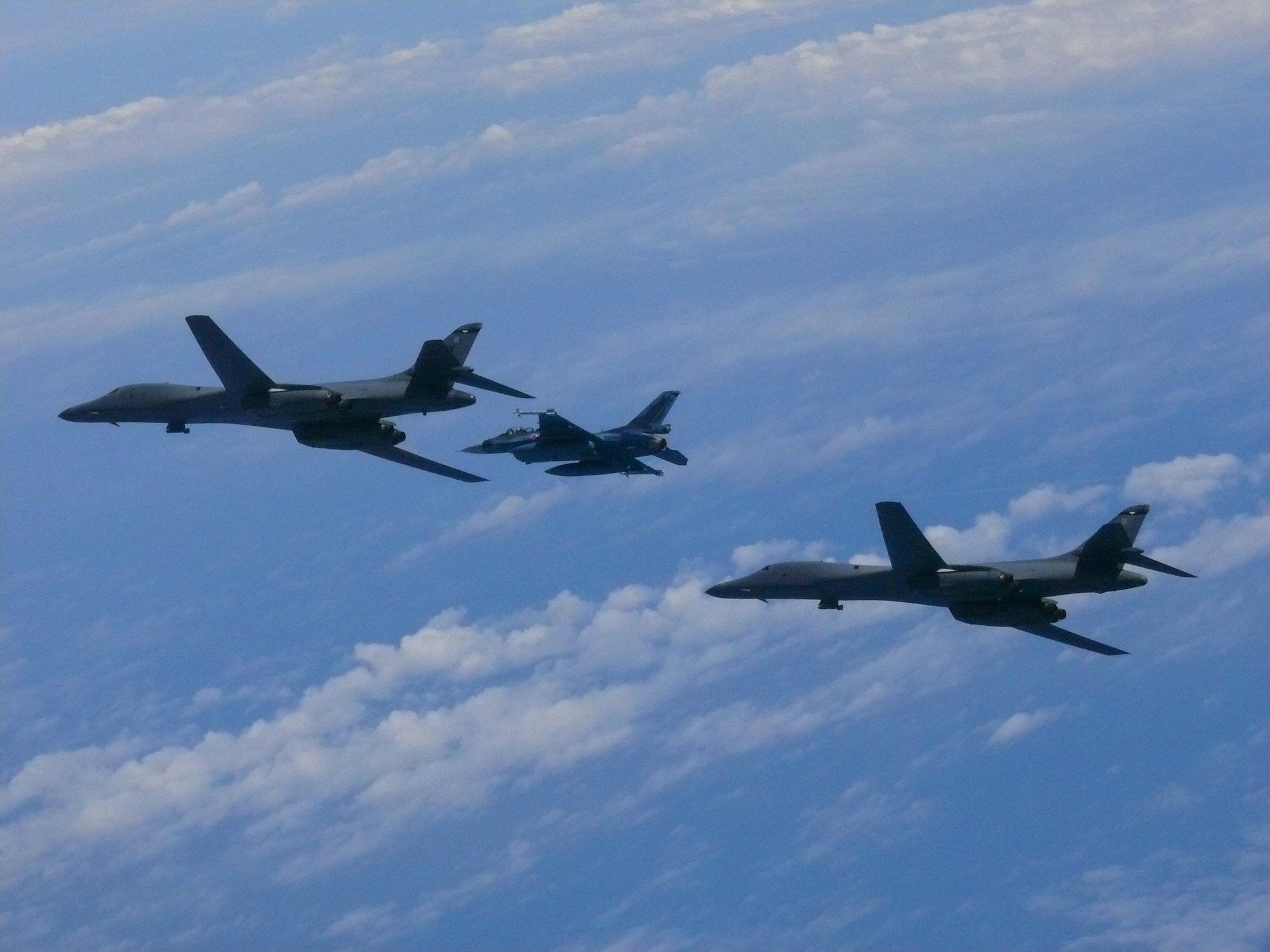 Two U.S. Air Force B-1B Lancers assigned to the 9th Expeditionary Bomb Squadron, deployed from Dyess Air Force Base, Texas, fly with a Koku Jieitai (Japan Air Self-Defense Force) F-2 fighter jet over the East China Sea, July 7. The Lancers departed Andersen Air Force Base, Guam to conduct a sequenced bilateral mission with South Korean F-15 and Koku Jieitai (Japan Air Self-Defense Force) F-2 fighter jets. The mission is in response to a series of increasingly escalatory action by North Korea, including a launch of an intercontinental ballistic missile (ICBM) on July 3. (photo courtesy of Japan Air Self-Defense Force)