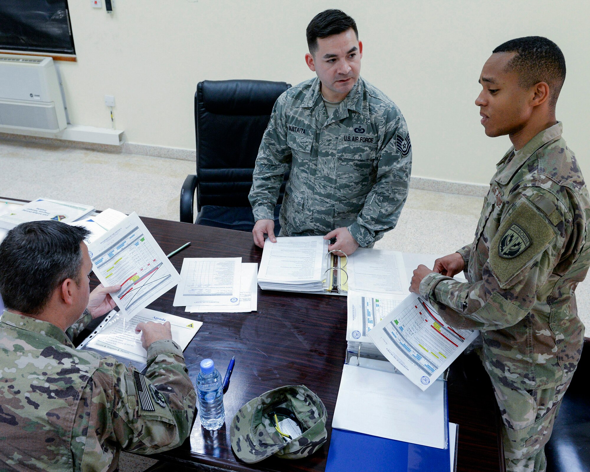 U.S. Air Force Tech. Sgt. Santino Sustaita, airfield driving program manager assigned to the 379th Expeditionary Office of Strategic Services, center, reviews training material with airfield driving trainers at Al Udeid, Air Force Base, Qatar, June 7, 2017. Airfield Management oversees more than 20 million square feet of airfield at Al Udeid in addition to overseeing the airfield driving program and filing all flight plans for flights arriving to and departing from the base. (U.S. Air National Guard photo by Tech. Sgt. Bradly A. Schneider/Released)