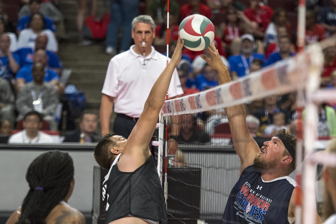 Navy veteran Petty Officer 3rd Class Nate Hamilton, right, and Army veteran Staff Sgt. Armando Gonzalez battle at the night during the sitting volleyball gold medal match during the 2017 Department of Defense Warrior Games at the United Center, Chicago, July 7, 2017.  Navy won gold, Army won silver, and Marines won bronze. DoD photo by EJ Hersom
