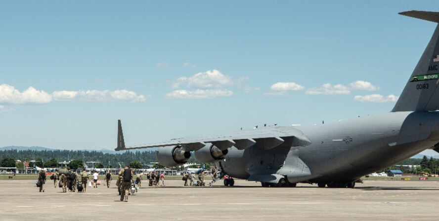 Members of the 304th Rescue Squadron walk to a C-17 in preparation for the unit’s largest deployment in its 60-year history, May 27, 2017, Portland, Oregon. (U.S. Air Force photo by Staff Sgt. Schaeffer Bonner)