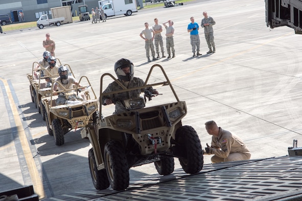 Members of the 304th Rescue Squadron drive all-terrain vehicles onto a C-5 Galaxy in preparation for the unit’s largest deployment in its 60-year history, May 27, 2017, Portland, Oregon. (U.S. Air Force photo by Staff Sgt. Schaeffer Bonner)