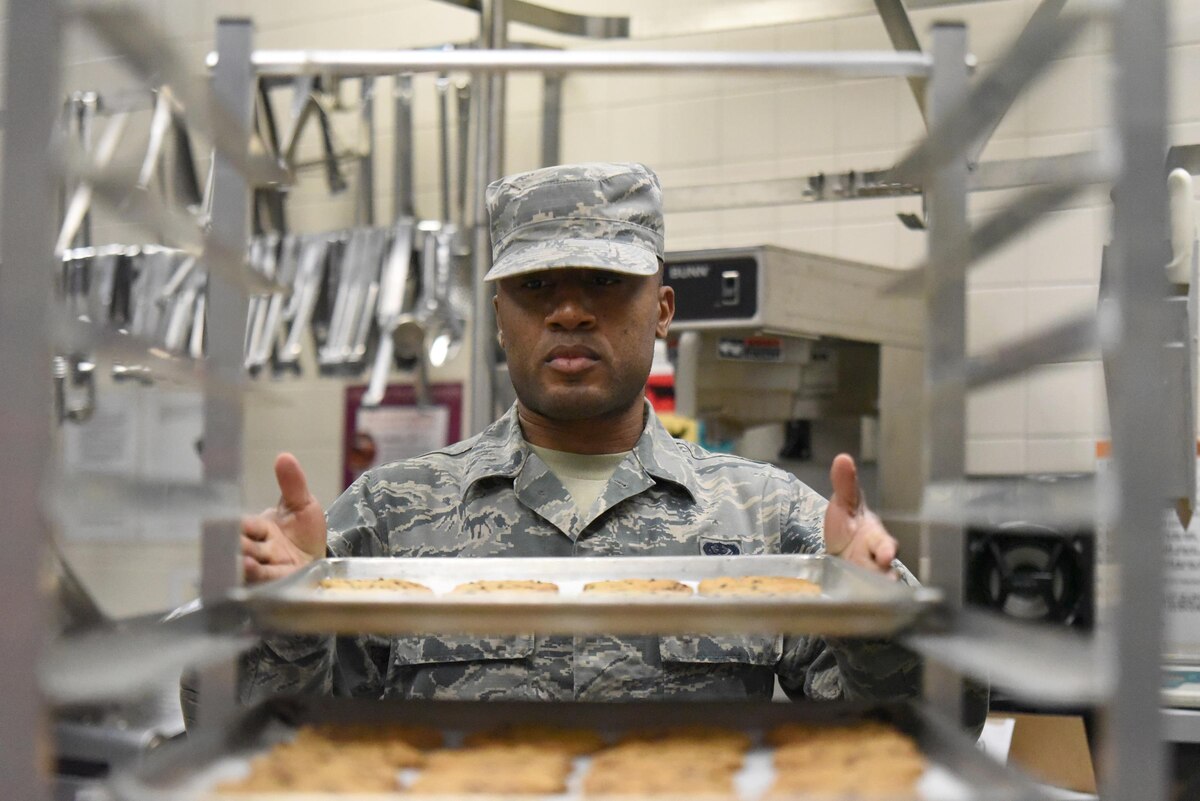 Senior Airman Raymond Ray, a cook for the Kentucky Air National Guard’s 123rd Services Flight in Louisville, Kentucky, stacks cookies that he spent the afternoon baking June 6, 2017. A variety of desserts are baked on site to be served to Airmen assigned here. The 123rd Services Flight recently was recognized as the best food service organization in the Air National Guard. (U.S. Air National Guard photo by Tech. Sgt. Vicky Spesard)