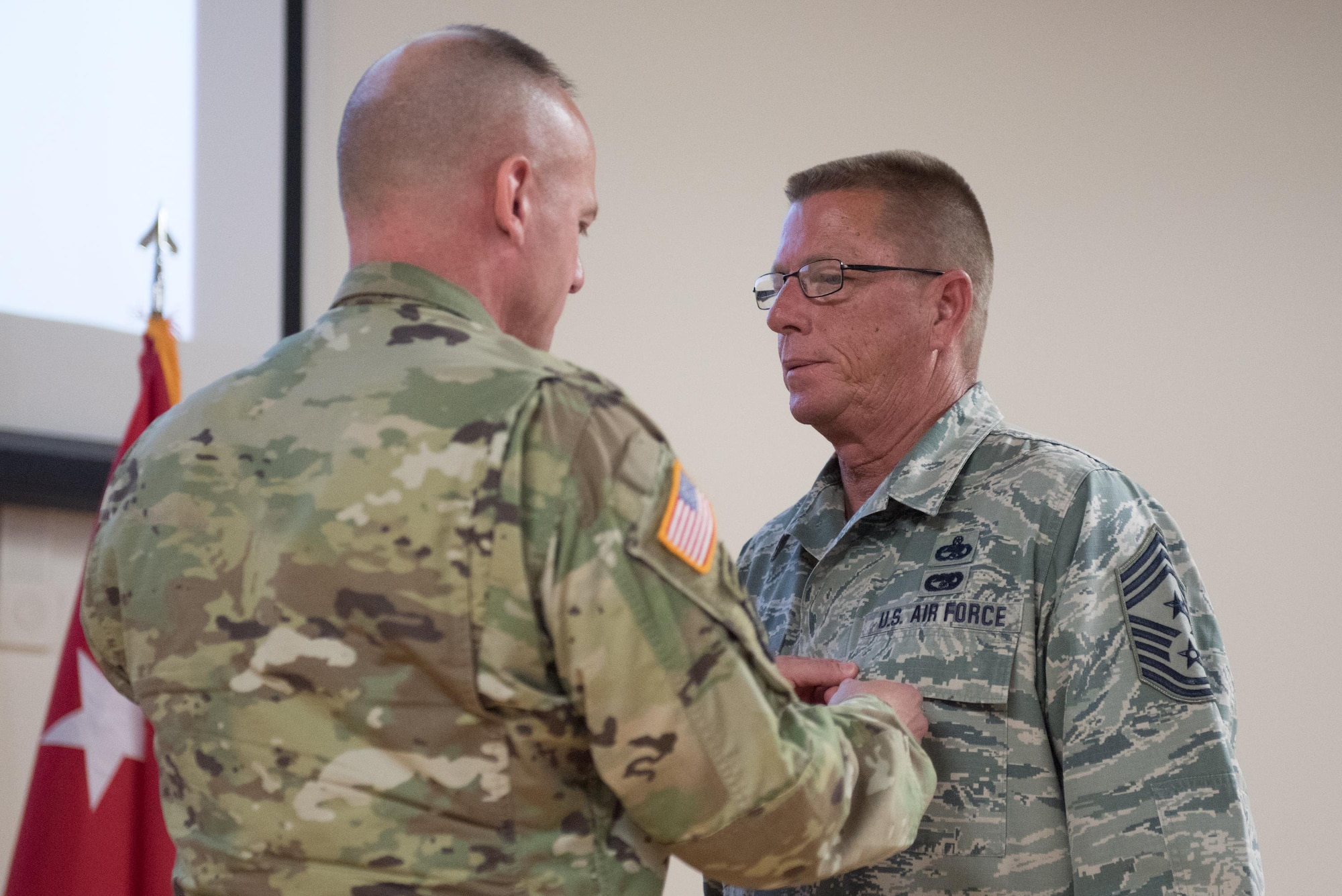 Army Maj. Gen. Stephen Hogan (left), the adjutant general for Kentucky, pins the Legion of Merit onto Chief Master Sgt. Jeffrey Moore (right), the outgoing state command chief master sergeant, during Moore’s retirement ceremony at the Kentucky Air National Guard base in Louisville, Ky., on May 20, 2017. Moore is retiring after 35 years of service to the Kentucky Air National Guard and United States Air Force. (U.S. Air National Guard photo by Staff Sgt. Joshua Horton)