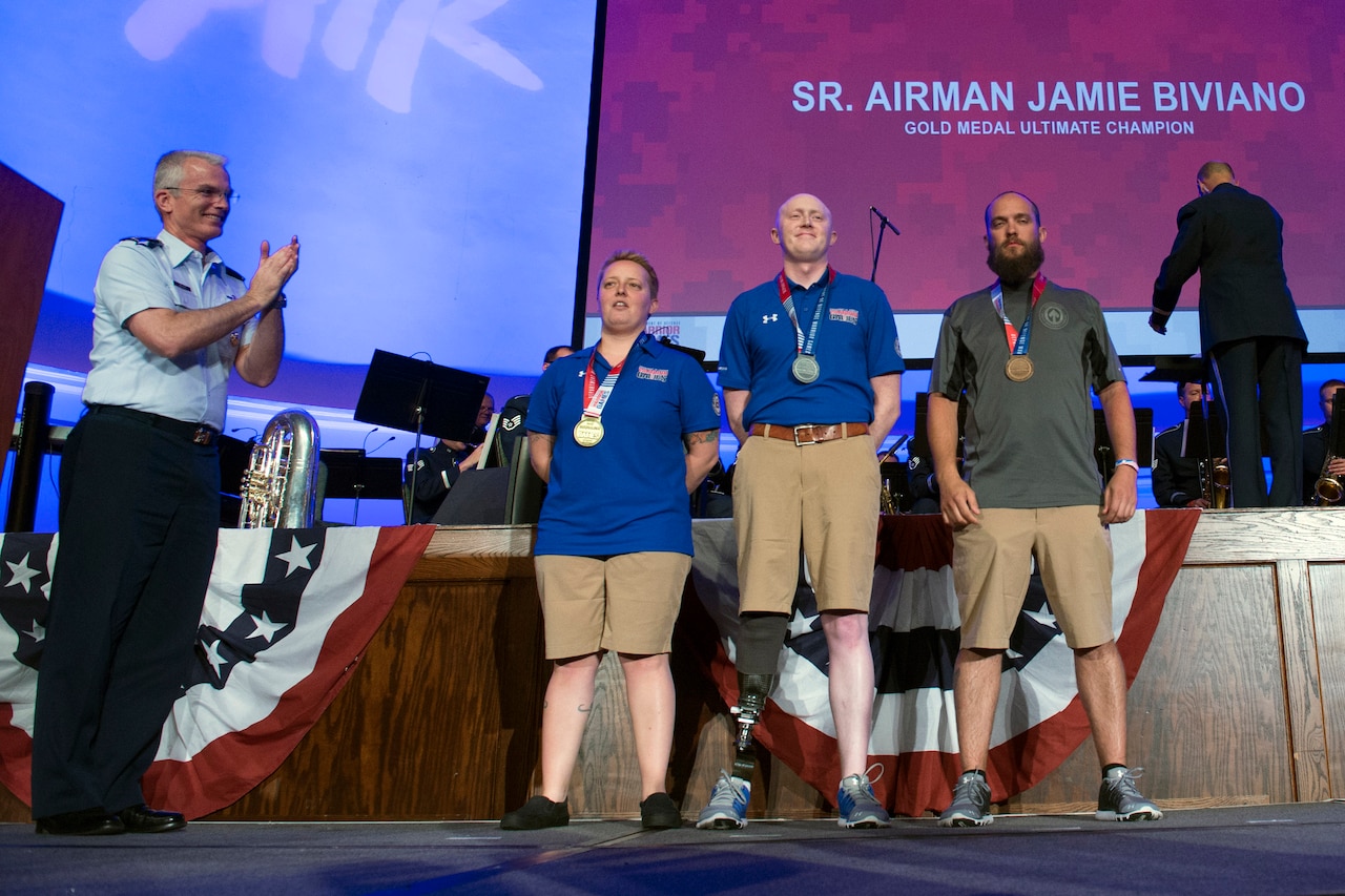 Air Force Gen. Paul J. Selva, vice chairman of the Joint Chiefs of Staff, applauds Ultimate Champion Medal recipients, from left, Air Force Senior Airman Jamie Biviano, gold, Air Force Capt. Austin Williamson, silver, and Marine Corps Staff. Sgt. John Stanz, bronze, during the 2017 Department of Defense Warrior Games in Chicago, July 8, 2017. DoD photo by EJ Hersom