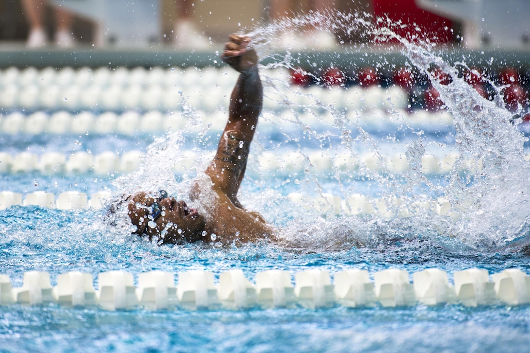 A competitor freestyle swims in a pool.