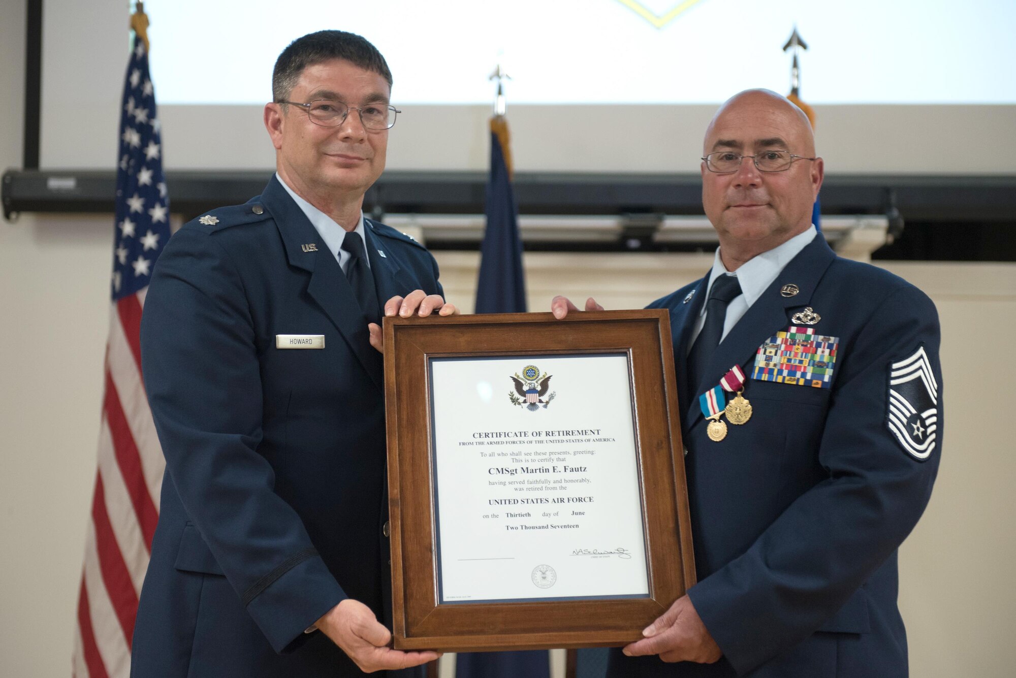 Chief Master Sgt. Martin E. Fautz (right), outgoing chief enlisted manager for the 123rd Civil Engineer Squadron, is presented with his certificate of retirement by retired Lt. Col. Phillip Howard, former commander of the squadron, during Fautz’s retirement ceremony at the Kentucky Air National Guard base in Louisville, Ky., on June 10, 2017. Fautz is retiring after more than 30 years of service to the Kentucky Air National Guard. (U.S. Air National Guard photo by Staff Sgt. Joshua Horton)
