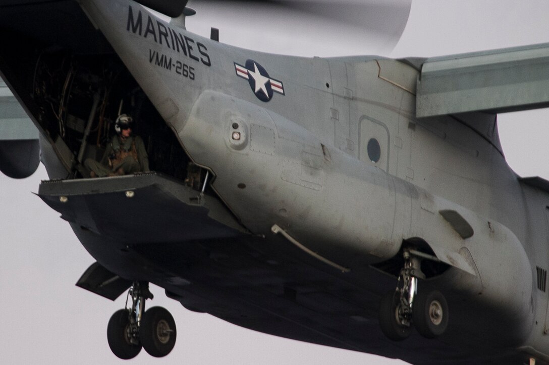 A Marine aviation crewman sits atop the exit ramp of an MV-22B Osprey tiltrotor aircraft after lifting off of the USS Bonhomme Richard (LHD 6) during flight operations while underway in the Pacific Ocean, July 7, 2017. The Osprey belongs to Marine Medium Tiltrotor Squadron 265 (Reinforced). VMM-265 (Rein.) and Marine Attack Squadron 311 combine to form the Aviation Combat Element of the 31st Marine Expeditionary Unit, currently supporting Talisman Saber 17 while deployed on its regularly-scheduled patrol of the Indo-Asia-Pacific region. Talisman Sabre is a biennial exercise designed to improve the interoperability between Australian and U.S. forces. The squadrons fly a variety of aircraft, including the MV-22B Osprey, AV-8B Harrier, CH-53E Super Stallion, AH-1Z Viper and UH-1Y Venom.