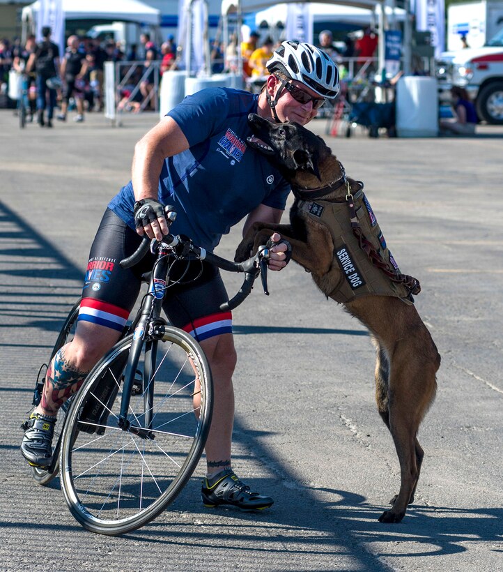 Navy veteran Ron Condrey exchanges greetings with Via, his military service dog, after winning the bronze medal in cycling during the 2017 Department of Defense Warrior Games in Chicago, July 6, 2017. Navy photo by Petty Officer 1st Class Mike DiMestico