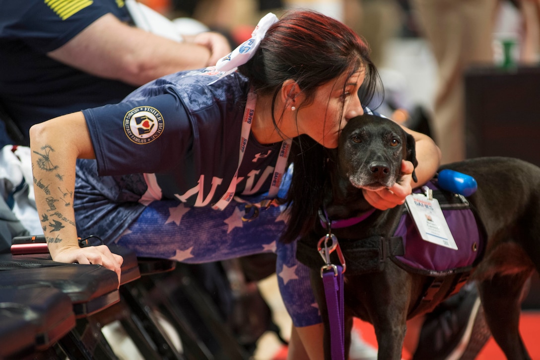 Retired Coast Guard Petty Officer 3rd Class Kristen Esget shares a moment with Breezey, a military service dog, before the start of the sitting volleyball game during the 2017 Department of Defense Warrior Games in Chicago, July 7, 2017. Navy photo by Petty Officer 2nd Class Lenny LaCrosse