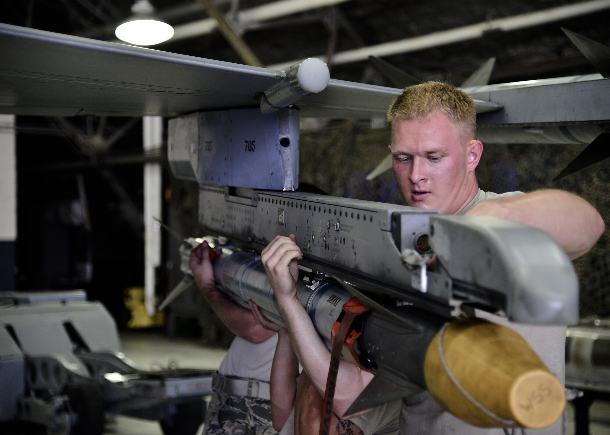 U.S. Air Force Airman 1st Class Daniel Namowicz, 36th Aircraft Maintenance Unit 2-man, loads a missile onto an F-16 Fighting Falcon during a quarterly 51st Maintenance Group weapons load competition at Osan Air Base, Republic of Korea, July 7, 2017. During the competition, each team was responsible for loading an AIM-9 Sidewinder, GBU-38 Joint Direct Attack Munition and GBU-12 Paveway II onto an aircraft frame in a timely manner. (U.S. Air Force photo by Airman 1st Class Gwendalyn Smith)
